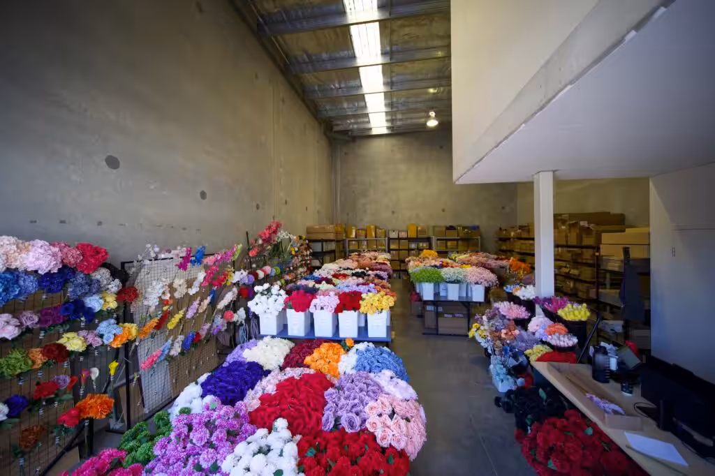 Racks of silk and artificial flowers in a range of colours stocked at The Silk Studio's Kogarah warehouse and trade showroom